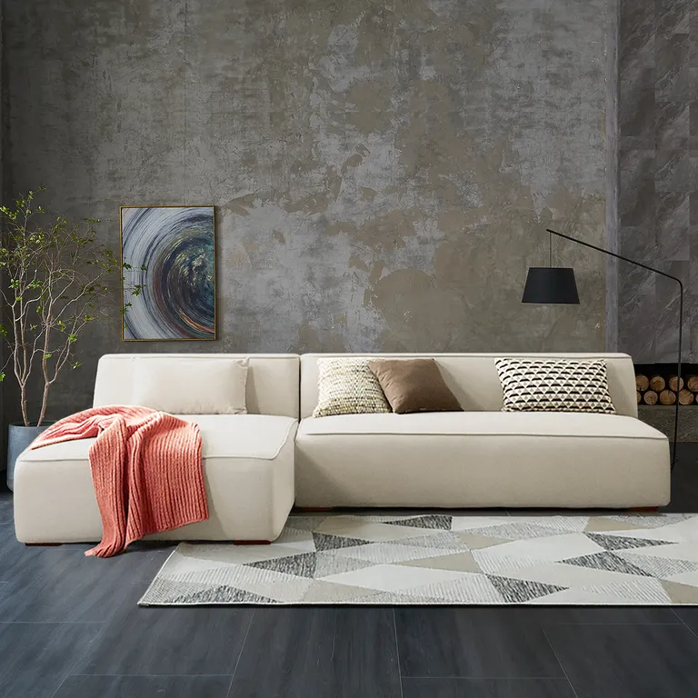 A contemporary living room featuring a white couch and a stylish rug, creating a cozy and inviting atmosphere.