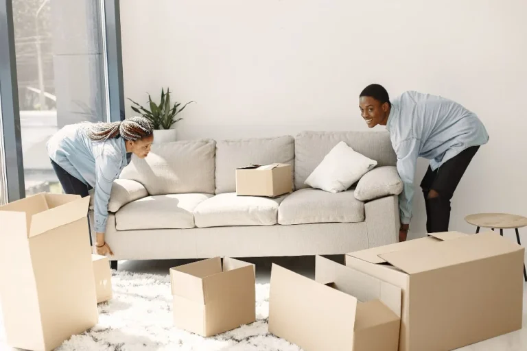 Couple arranging sofa in their living room