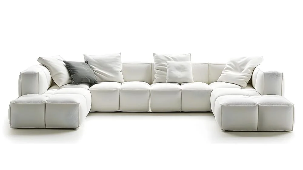 A modern white leather sectional sofa adorned with decorative pillows, showcasing a stylish and inviting living space.