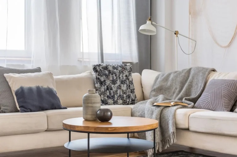 A cozy Living Room featuring an L-shaped sofa with nicely patterned throws and gorgeous coffee table