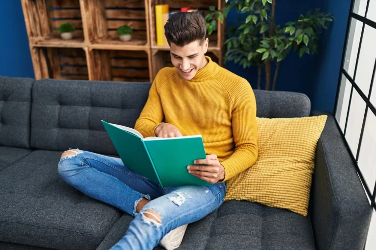 A man reading a book on an elegant L-shaped sofa that makes a unique reading nook.