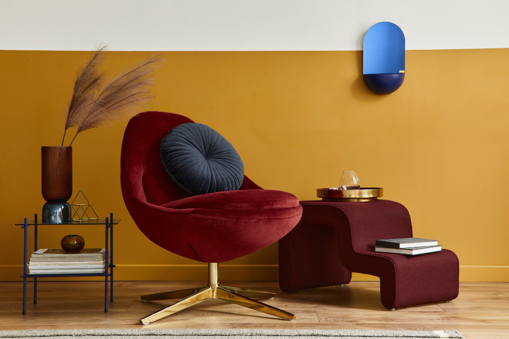 A chair and a table positioned against a bright yellow wall, creating a vibrant and inviting atmosphere.