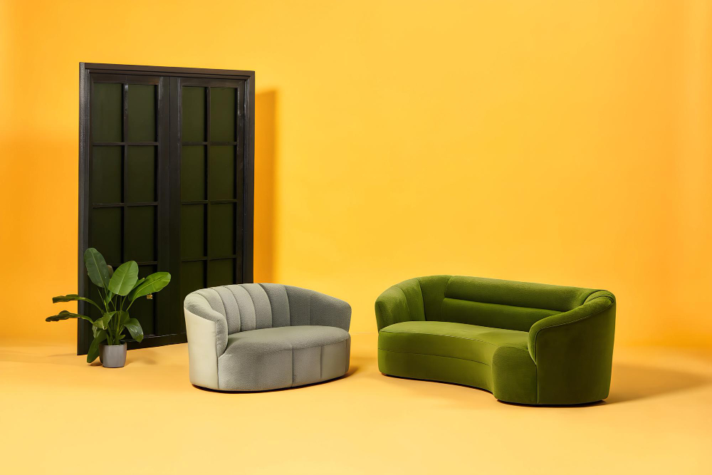 Two green sofas positioned in front of a bright yellow wall, creating a vibrant and inviting living space.